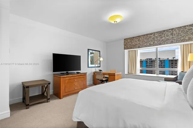 a bedroom with furniture and flat screen tv