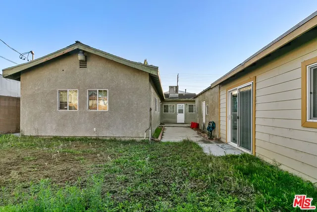 a view of a house with backyard and sitting area