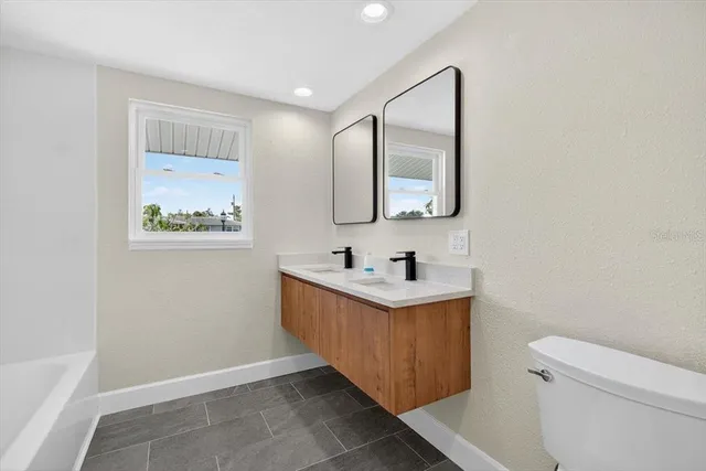 a bathroom with a bathtub sink mirror and toilet