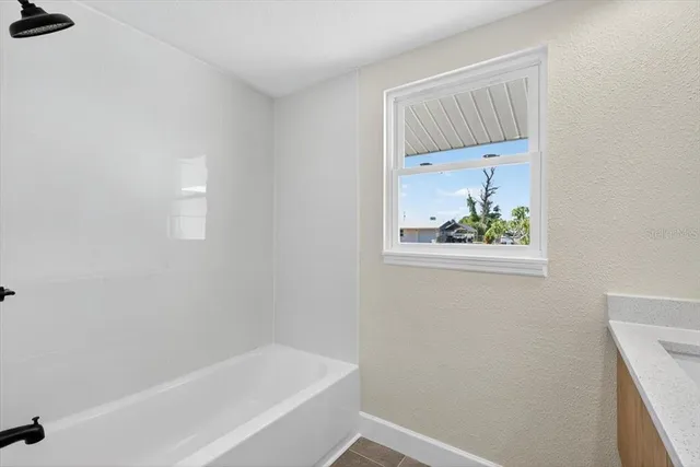 view of bathroom with bathtub and window