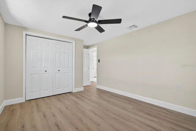 a view of a room with wooden floor closet and windows