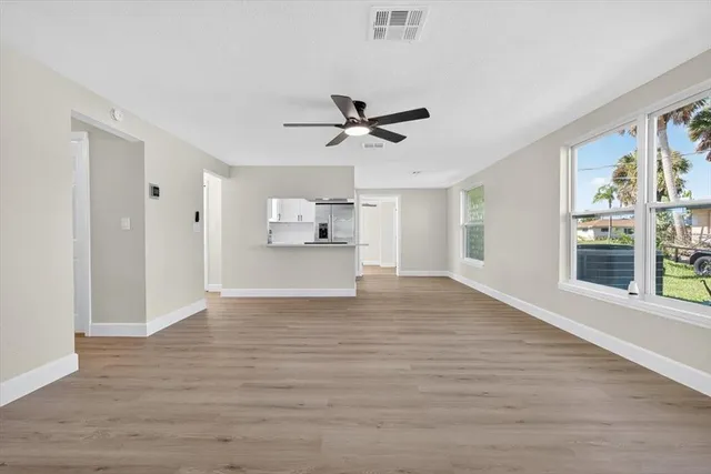 a view of a kitchen with wooden floor and a ceiling fan
