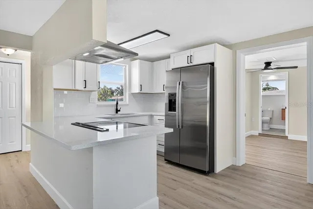 a kitchen with stainless steel appliances granite countertop a refrigerator a sink and a stove