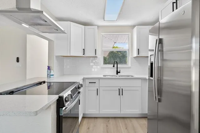 a kitchen with a sink cabinets and stainless steel appliances