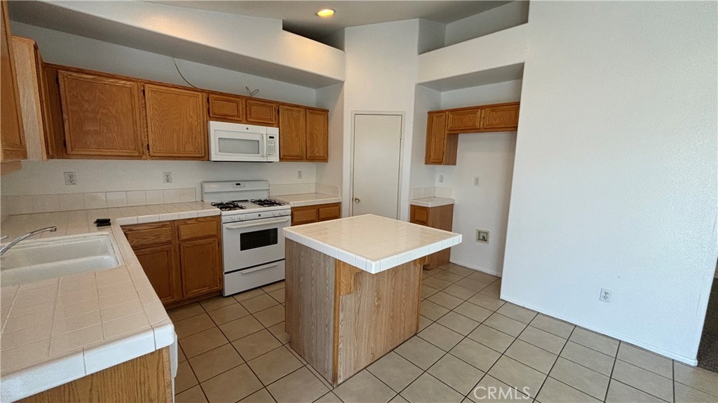 875 South Gilbert Street Hemet, CA 92543 - Photo 4 of 5 a kitchen with a sink stove and cabinets