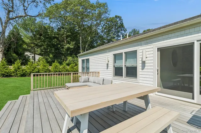a view of a deck with a table and chairs next to a yard