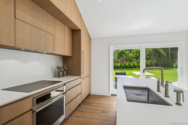 a kitchen with stainless steel appliances granite countertop a stove and a white cabinets
