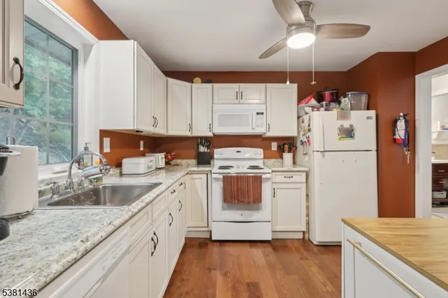 a kitchen with white cabinets and white appliances