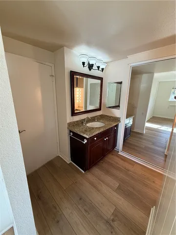 a kitchen with granite countertop a stove wooden floor and cabinets