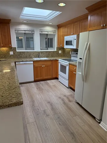 a large kitchen with granite countertop a refrigerator and a stove