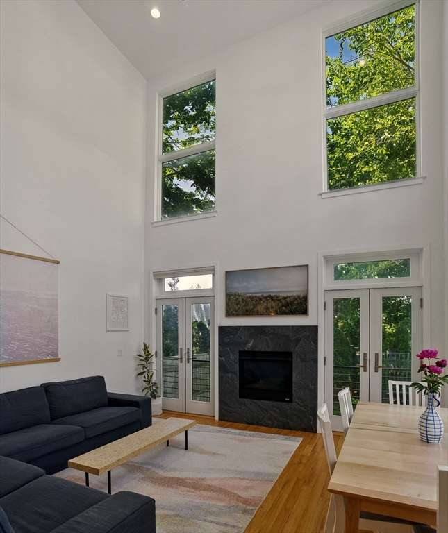 151 Sherman Street Cambridge, MA 02140 - Photo 14 of 35 a living room with furniture a fireplace and a floor to ceiling window