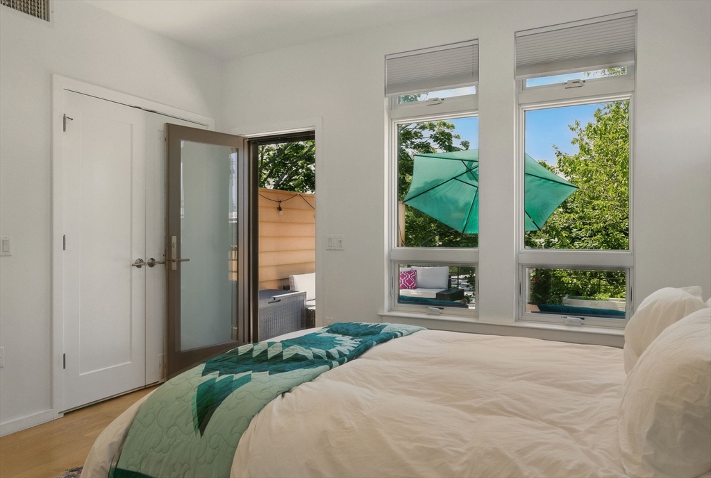 151 Sherman Street Cambridge, MA 02140 - Photo 29 of 35 a bedroom with a bed and a large window