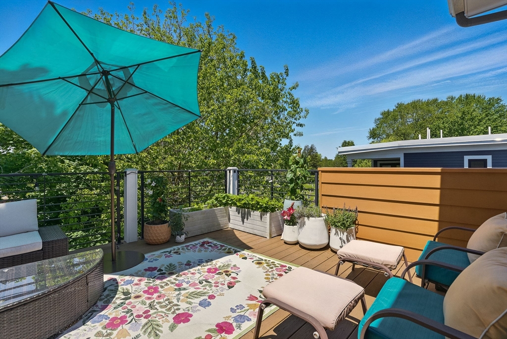151 Sherman Street Cambridge, MA 02140 - Photo 31 of 35 a view of a patio with couches table and chairs under an umbrella