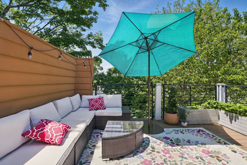 151 Sherman Street Cambridge, MA 02140 - Photo 32 of 35 a view of a backyard with furniture and an umbrella