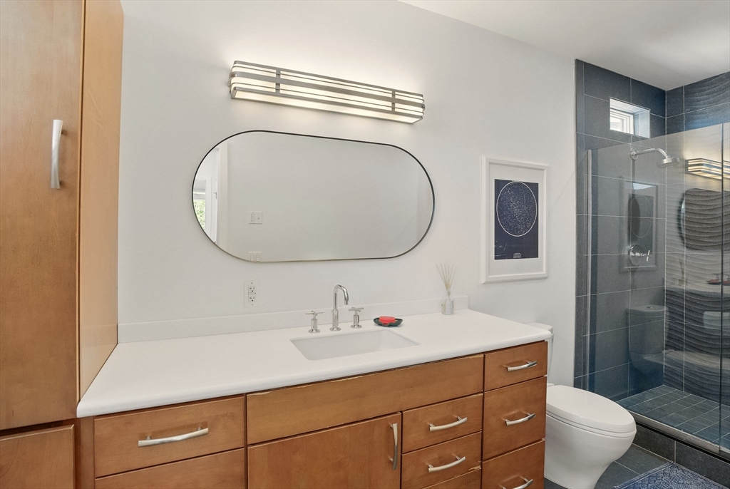 151 Sherman Street Cambridge, MA 02140 - Photo 34 of 35 a bathroom with a sink a toilet and a mirror