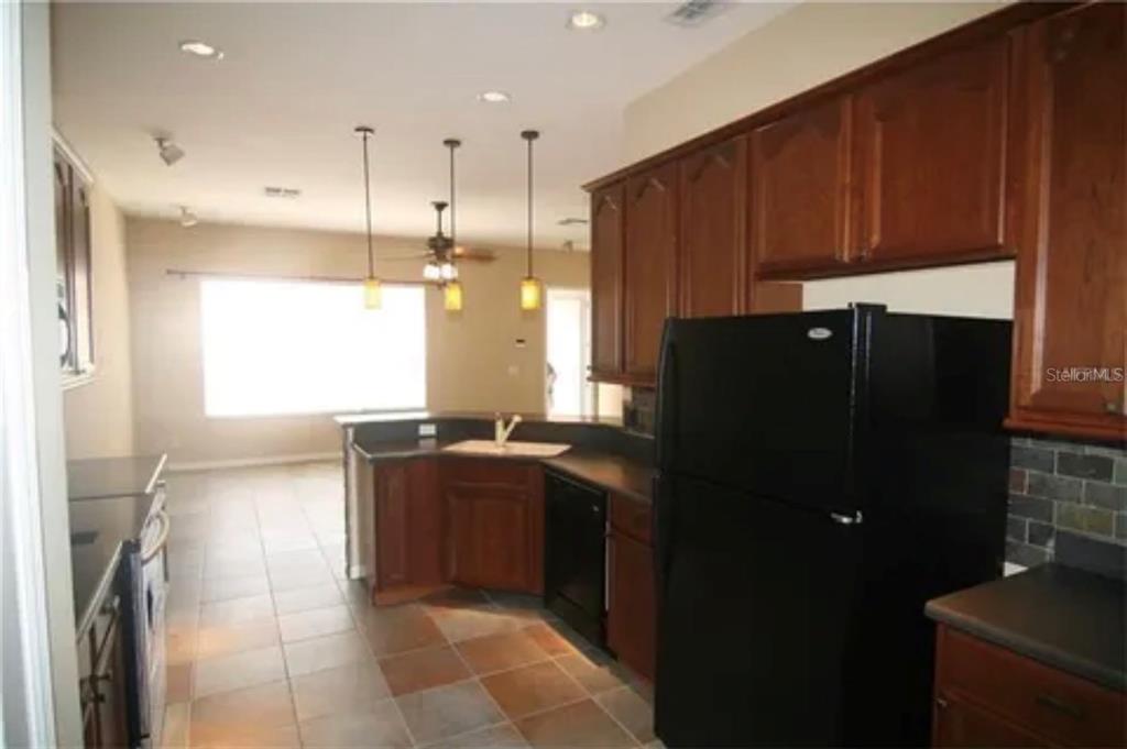 1518 Tally Circle Oviedo, FL 32765 - Photo 5 of 15 a kitchen with granite countertop a refrigerator and a stove top oven