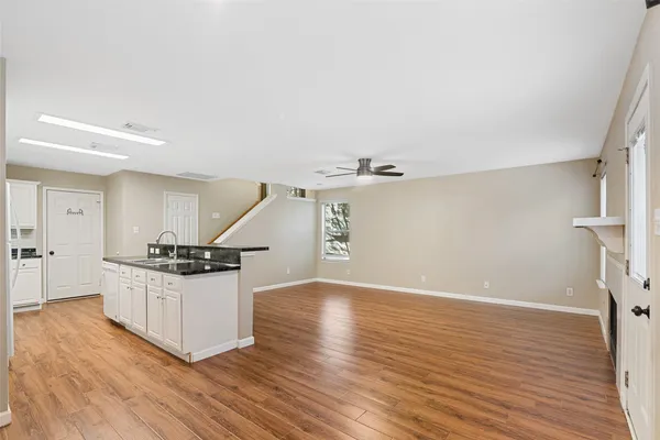 a kitchen with granite countertop a stove and a wooden floor