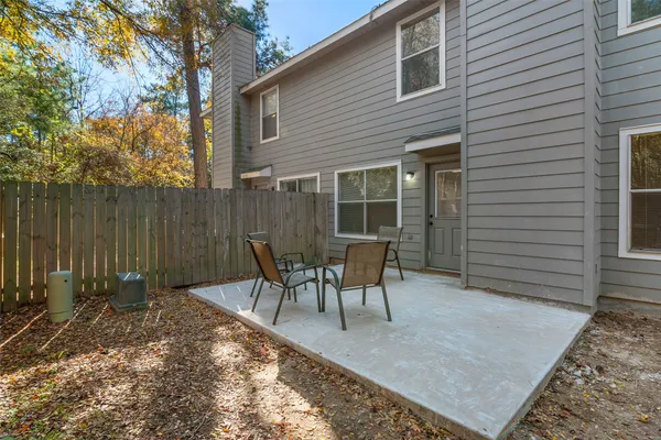 a view of a patio with table and chairs and wooden fence