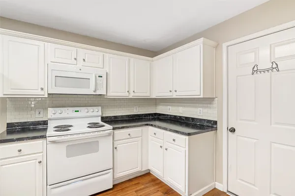 a kitchen with white cabinets and white appliances