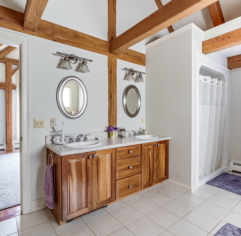 60 Emerald Road Rutland, MA 01543 - Photo 23 of 42 a bathroom with a sink a mirror and clock on the wall