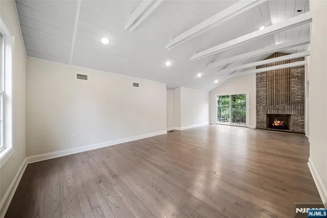an empty room with wooden floor and a window