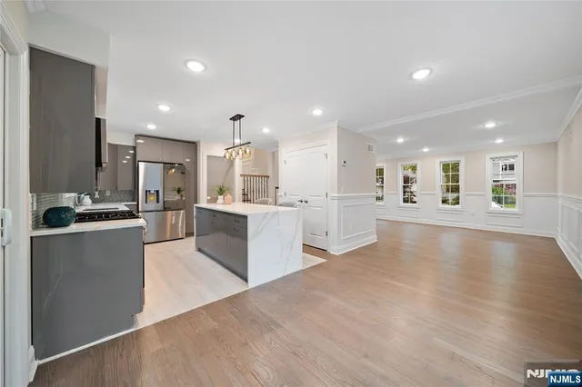 a view of kitchen with kitchen island sink refrigerator and white cabinets