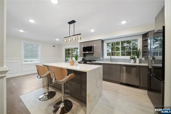 a kitchen with granite countertop a sink and a refrigerator