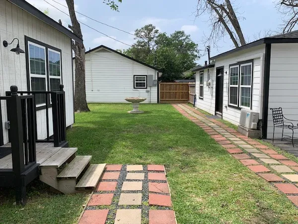 a backyard of a house with barbeque oven table and chairs