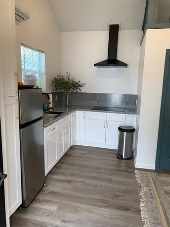 a kitchen with granite countertop a sink and a refrigerator