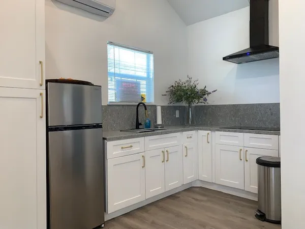 a kitchen with stainless steel appliances granite countertop a refrigerator sink and white cabinets