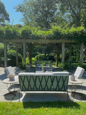 a view of a chair and table in backyard of the house