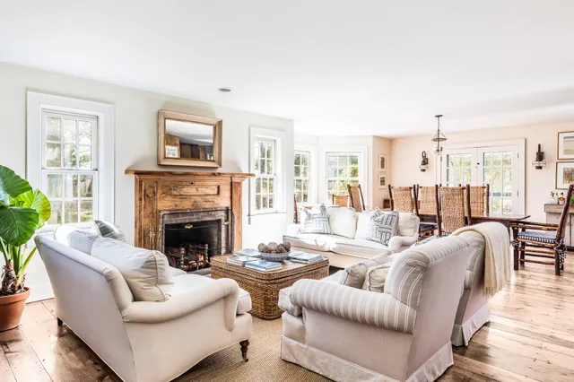 a living room with furniture fireplace and a large window