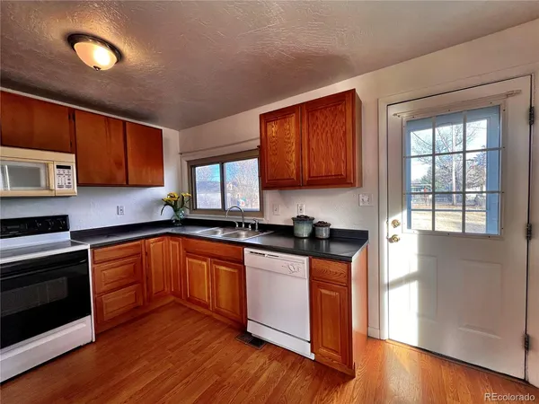 a kitchen with stainless steel appliances granite countertop wooden cabinets a sink and a stove