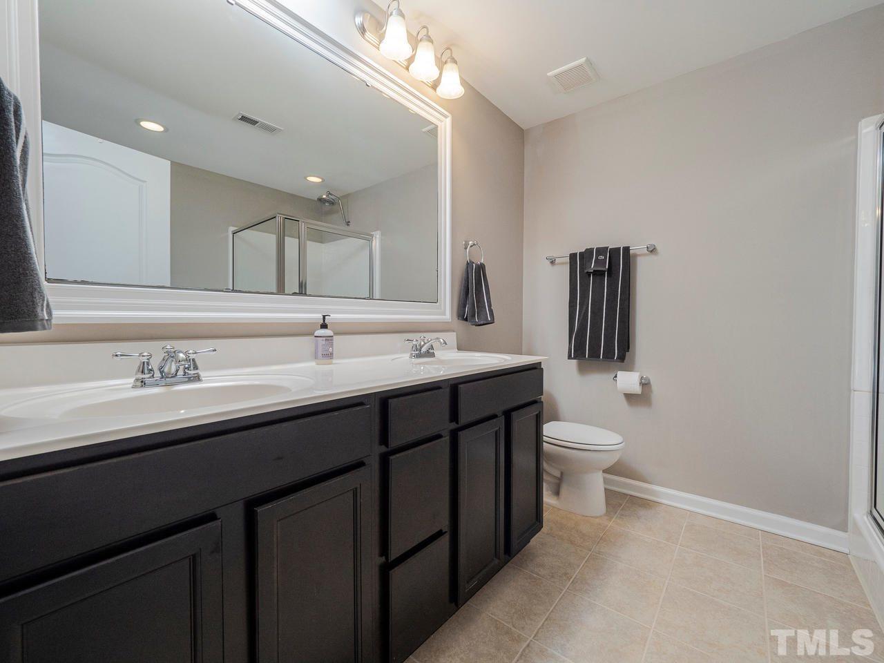1001 Ileagnes Road Raleigh, NC 27603 - Photo 15 of 26 a bathroom with a toilet sink double vanity and mirror