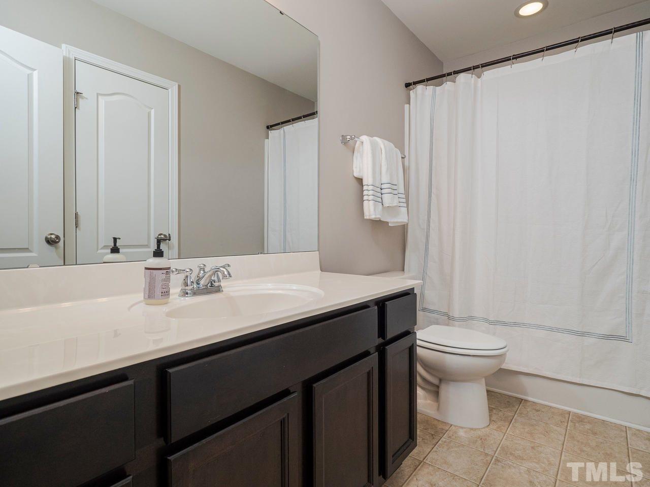 1001 Ileagnes Road Raleigh, NC 27603 - Photo 19 of 26 a bathroom with a granite countertop sink a toilet and a mirror