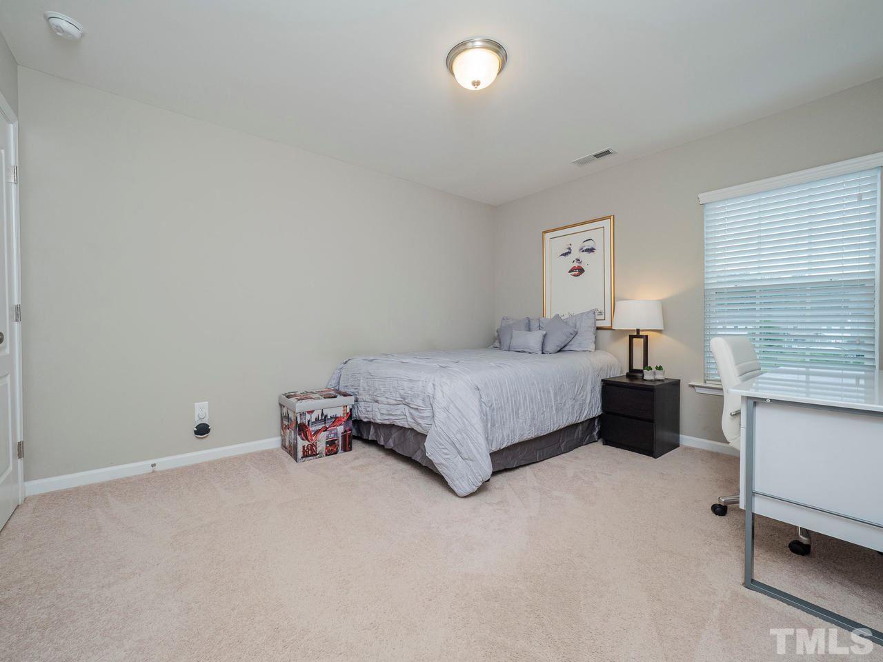 1001 Ileagnes Road Raleigh, NC 27603 - Photo 20 of 26 a bedroom with a bed and a chair