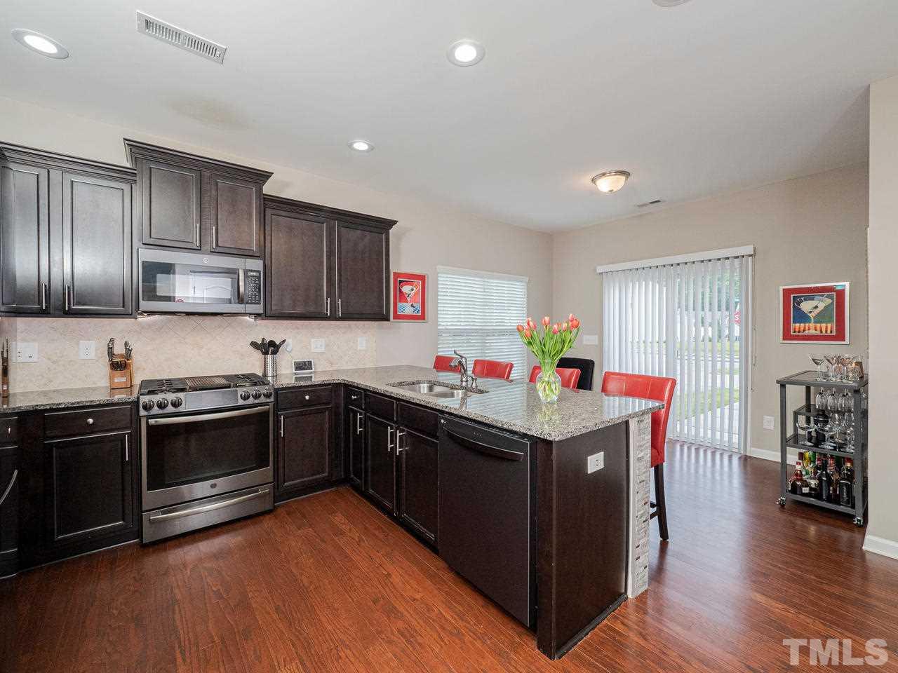 1001 Ileagnes Road Raleigh, NC 27603 - Photo 7 of 26 a kitchen with wooden cabinets and stainless steel appliances