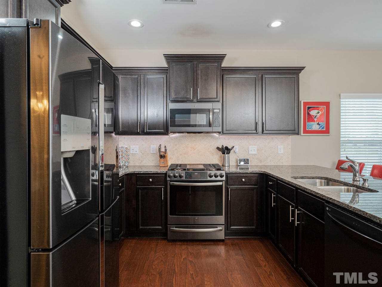 1001 Ileagnes Road Raleigh, NC 27603 - Photo 8 of 26 a kitchen with stainless steel appliances granite countertop a sink stove and refrigerator