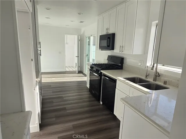 a kitchen with granite countertop a sink and a stove top oven