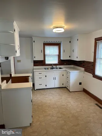 a kitchen with granite countertop a sink a stove and cabinets