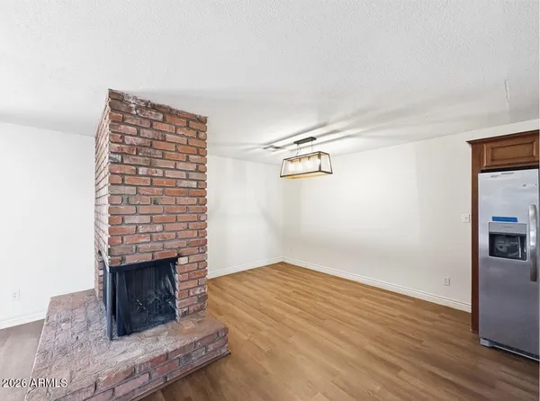 a view of empty room with wooden floor and fireplace