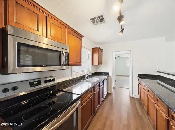 a kitchen with stainless steel appliances a stove microwave and cabinets