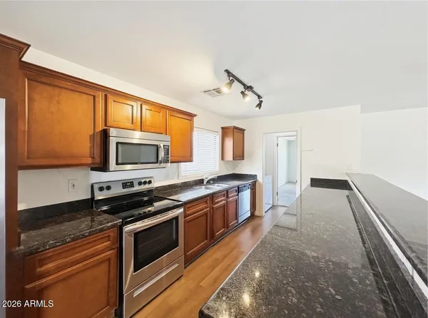a kitchen with stainless steel appliances a stove sink and microwave