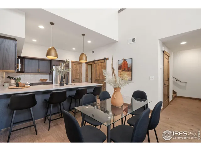 a open kitchen with stainless steel appliances kitchen island granite countertop a table chairs sink and cabinets