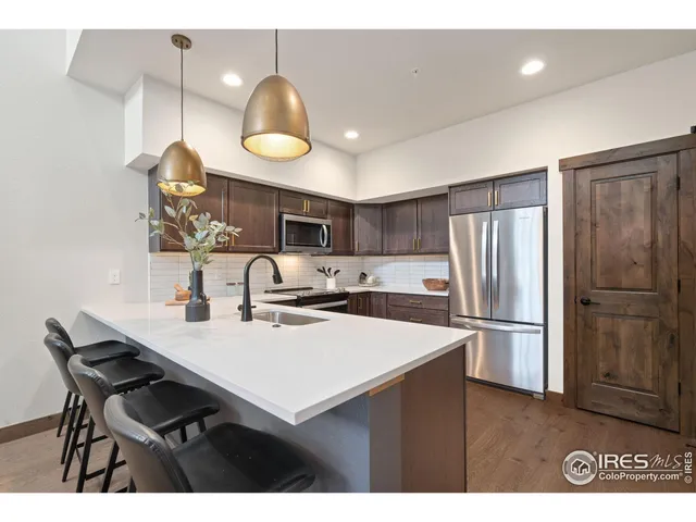 a kitchen with kitchen island granite countertop a sink stainless steel appliances and cabinets