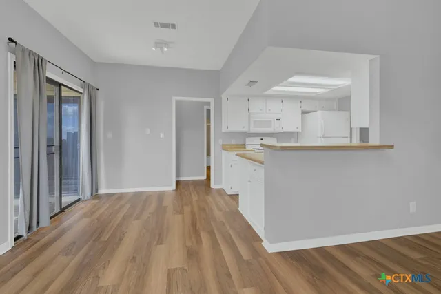 a view of a kitchen with wooden floor and a sink