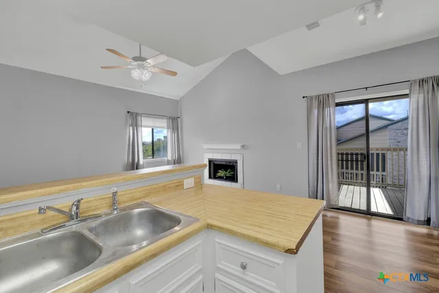 a view of a kitchen with a sink and dishwasher with wooden floor