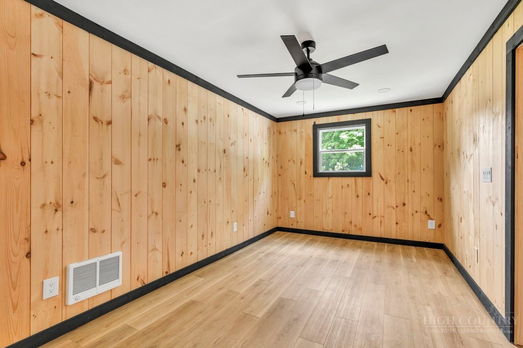 209 Meadow Loop Newland, NC 28657 - Photo 17 of 30 a view of a livingroom with wooden floor a ceiling fan and windows