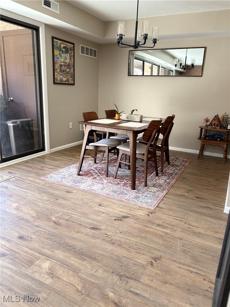 935 Canyon View Road, Unit 104 Northfield, OH 44067 - Photo 10 of 46 Dining room with an inviting chandelier, wood finished floors, baseboards, and visible vents
