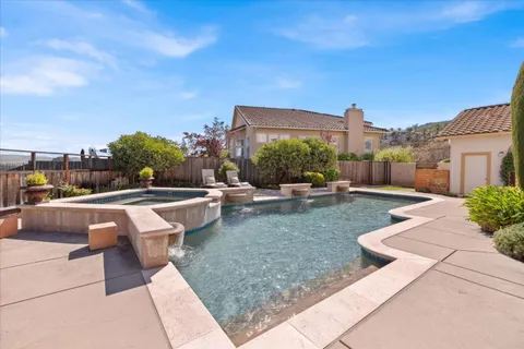 a view of a house with swimming pool and sitting area